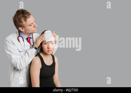 Réglage médecin bandage sur la tête du patient Banque D'Images