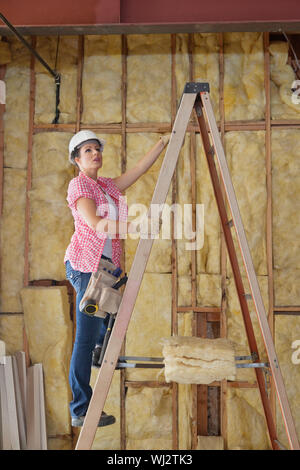 Femme entrepreneur de grimper l'échelle at construction site Banque D'Images