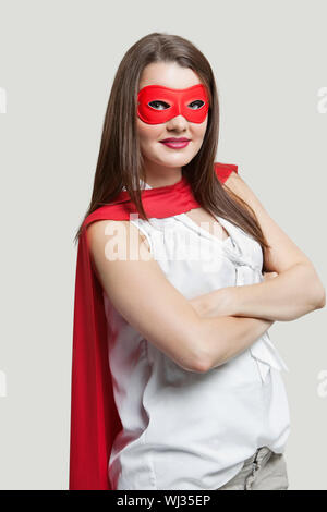 Portrait d'une jeune femme en costume de super-héros sur fond gris Banque D'Images