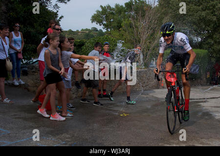 Action de la course à vélo, une très courte montée dash, dans le village d'Mianigues, Pla d'lestany, Gérone, Espagne. Les concurrents sont arrosés fans. Banque D'Images