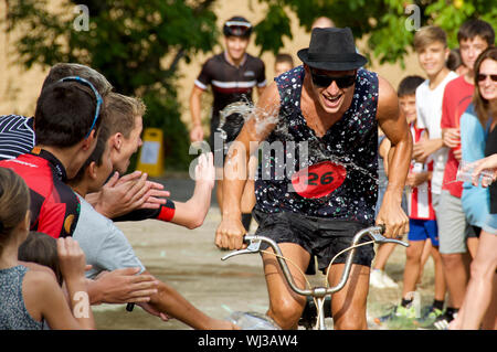 Action de la course à vélo, une très courte montée dash, dans le village d'Mianigues, Pla d'lestany, Gérone, Espagne. Les concurrents sont arrosés fans. Banque D'Images