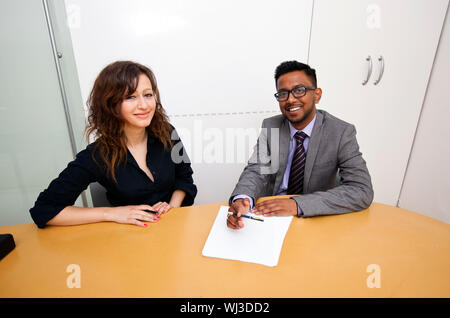 Travail multi-ethnique collègues signer des documents sur une table Banque D'Images