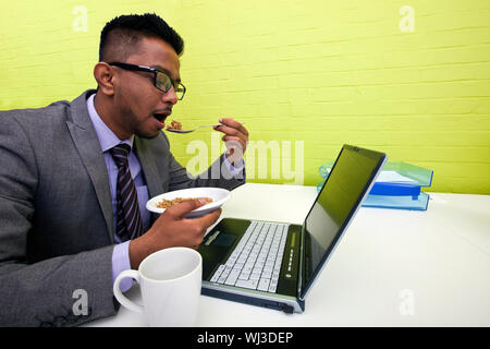 Close up of woman eating at her desk Banque D'Images