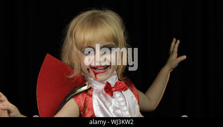 Dracula enfant. Petite fille halloween avec make-up faisant des grimaces. Enfant Vampire avec du sang sur son visage. Happy Halloween de concept d'horreur. Vendredi 13 thème Banque D'Images