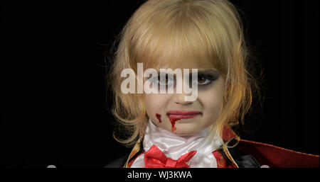 Dracula enfant. Petite fille halloween avec make-up faisant des grimaces. Enfant Vampire avec du sang sur son visage. Happy Halloween de concept d'horreur. Vendredi 13 thème Banque D'Images