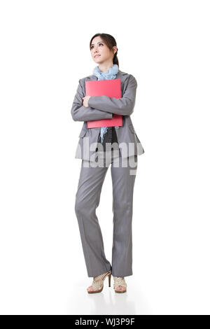 Confident business woman regarder au loin et tenir un document, full length portrait isolé sur fond blanc. Banque D'Images