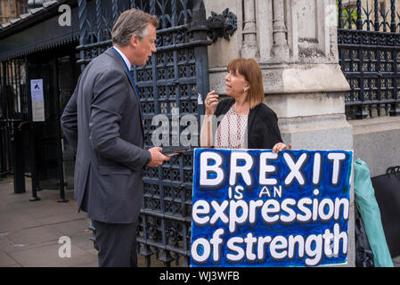 Les députés ont commencé à arriver au Palais de Westminster pour reprendre leurs fonctions après les vacances d'été, au moins jusqu'à la prorogation du Parlement la semaine prochaine. Tom Newton Dunn parle aux manifestants devant le Parlement Banque D'Images