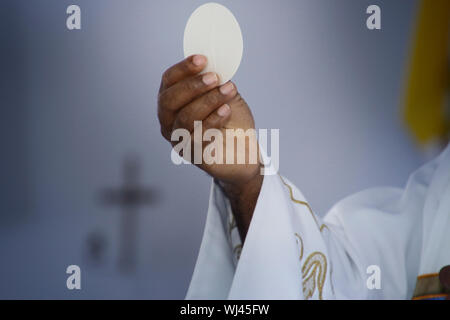 Wafer sainte. La sainte communion dans l'église. Prendre la sainte Communion. Prêtre de célébrer la messe à l'église. Tasse de verre avec du vin rouge, du pain. Fête du Corpus C Banque D'Images