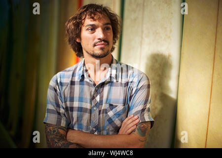 Portrait confiant homme surf shop owner with arms crossed Banque D'Images