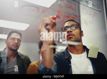 Les jeunes gens d'affaires de démarrage créative réunion au bureau moderne à faire des plans sur du verre transparent Banque D'Images