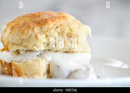 Biscuits américains à partir de rien servi avec sauce au jus de saucisse blanche épaisse. Focus sélectif contre fond blanc. Banque D'Images