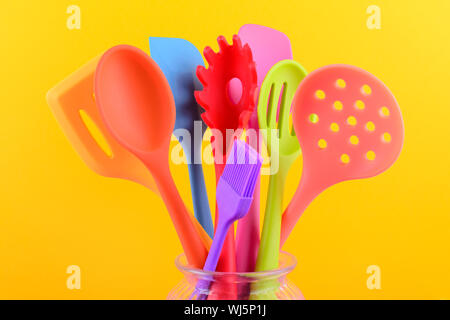 Des ustensiles de cuisine lumineuse multicolore sur fond jaune Banque D'Images