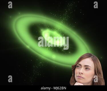 Image composite de concentré de jolie brunette posing in front of green background galaxy Banque D'Images