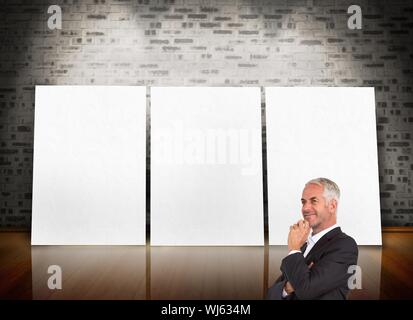 Composite image of thoughtful businessman crossing arms devant trois écrans blanc Banque D'Images