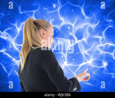Image composite de blond businesswoman pointing sur fond bleu futuriste rougeoyant Banque D'Images