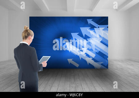 Image composite de blond businesswoman holding new tablet Banque D'Images