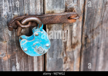 Old rusty bleu cadenas déverrouillé sur porte en bois Banque D'Images