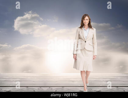 Image composite de smiling brunette businesswoman walking Banque D'Images