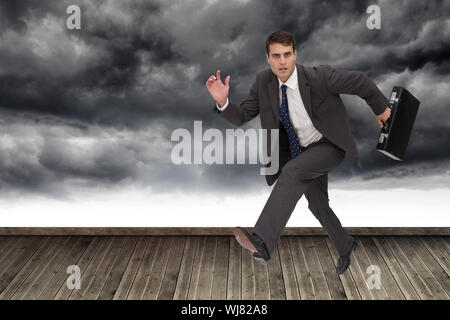 Image composite de stern attractive businessman dans un hury Banque D'Images