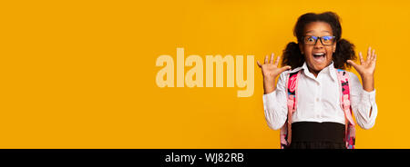 Surpris African American Schoolgirl crier sur fond jaune Banque D'Images