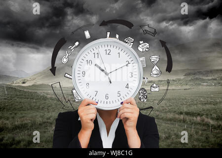 Composite image of businesswoman in suit holding a clock Banque D'Images