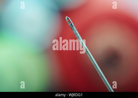 Aiguille à coudre sur un fond coloré. Extrêmement close-up photo Banque D'Images