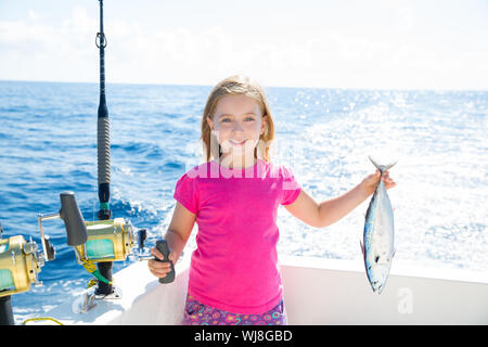 Kid girl blonde Thon pêche au thon à la traîne peu heureux avec capture sur pont de bateau Banque D'Images