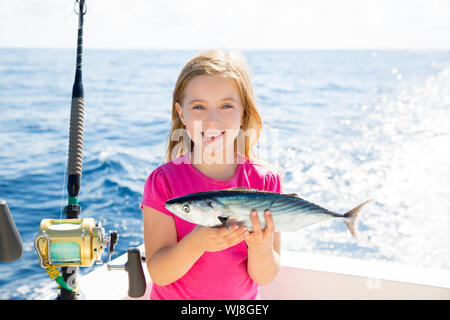 Kid girl blonde Bonito Thon pêche poissons sarda heureux avec des prises à la traîne sur pont de bateau Banque D'Images