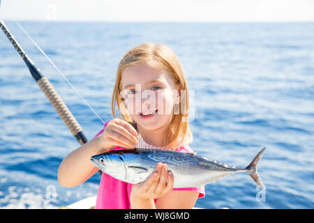 Kid girl blonde Thon pêche au thon à la traîne peu heureux avec capture sur pont de bateau Banque D'Images