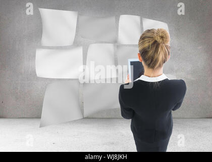 Image composite de blond businesswoman holding new tablet Banque D'Images