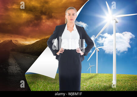 Image composite de blond businesswoman standing with hands on hips Banque D'Images