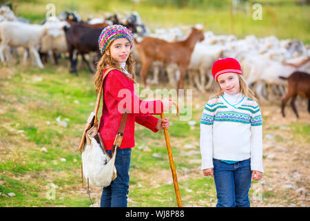 Kid girl bergère sœurs heureux avec troupeau de moutons et bâton en bois en Espagne Banque D'Images