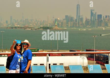 Prendre un passager en selfies sur les toits de la ville de New York, alors qu'à bord de l'hymne national de la mer Royal Caribbean Cruise bateau amarré au port. Banque D'Images