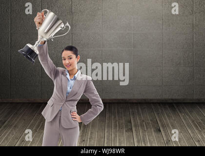 Composite image of businesswoman showing a cup Banque D'Images