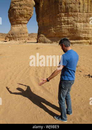 Une drôle d'image d'un homme soutenant avec son ombre (grâce à la manipulation de l'image) en face de la roche de l'éléphant à Al-'ula, l'Arabie saoudite (K Banque D'Images