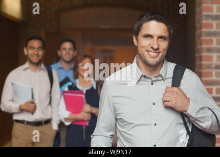 Casual mature student couloir avec sa classe à l'arrière-plan Banque D'Images