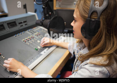 L'accent assez watching TV assis dans le studio du college Banque D'Images