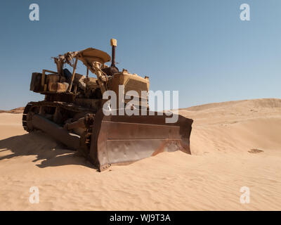Un vieux bulldozer abandonné au milieu du désert en Arabie Saoudite. Machines de Construction Banque D'Images