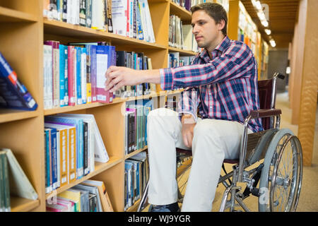 L'homme en fauteuil roulant la sélection à partir de bibliothèque dans la bibliothèque Banque D'Images