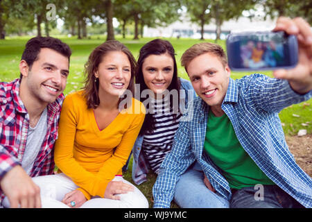 Heureux homme prendre photo avec ses amis dans le parc du collège Banque D'Images