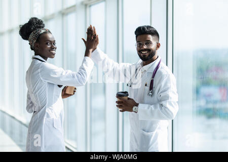 Longueur totale d'un homme indien et africain femme médecin désignant les cinq isolé sur fond blanc Banque D'Images