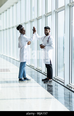 Longueur totale d'un homme et femme médecin désignant les cinq isolé sur fond blanc Banque D'Images