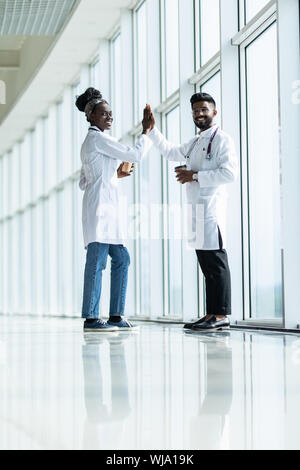 Longueur totale d'un homme indien et africain femme médecin désignant les cinq isolé sur fond blanc Banque D'Images