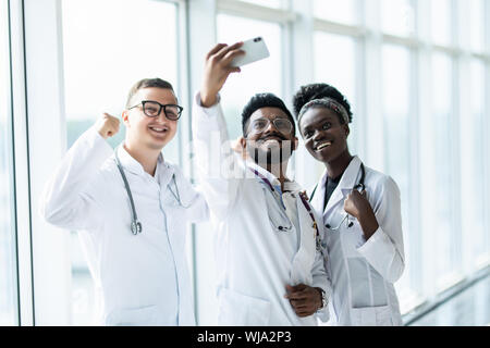 Groupe de médecins stagiaires en tenant vos autoportraits dans le hall de l'hôpital Banque D'Images
