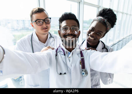 Groupe de médecins stagiaires en tenant vos autoportraits dans le hall de l'hôpital Banque D'Images