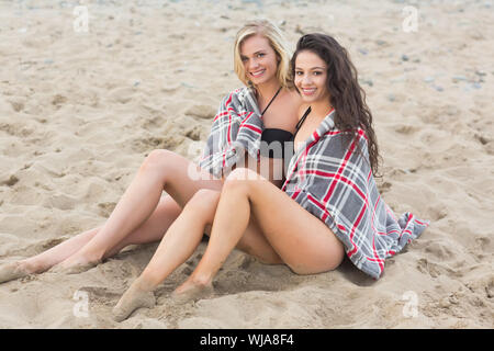 Portrait de deux jeunes femmes couvertes de couverture à la plage Banque D'Images