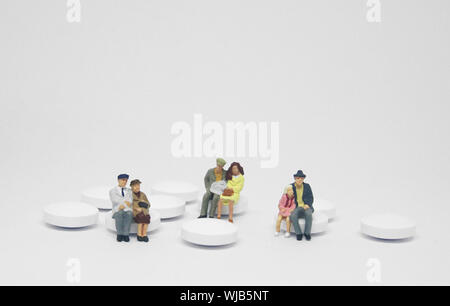 Couple de personnes âgées famille figure assis sur un tas de pilules blanches. Banque D'Images