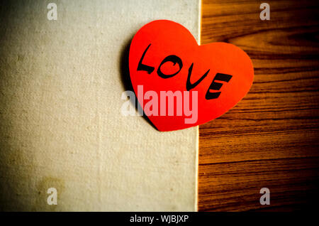 Ordinateur portable avec coeur lettre amour sur fond de bois de style vintage Banque D'Images