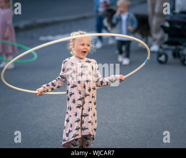 Les enfants jouent avec des cerceaux, Menningarnott ou culturel 24, Reykjavik, Islande. Rue fermée hors de voitures. Banque D'Images