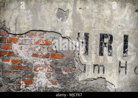 Mur de brique extérieur rendus vintage avec des fragments de lettres. Banque D'Images